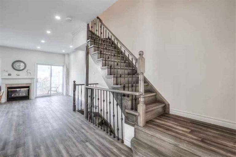 This Thornhill interior renovation highlights a beautifully upgraded staircase with modern iron railings, refinished wood steps, and new wood-style flooring throughout the main floor. The open-concept layout is enhanced with fresh paint, recessed lighting, and improved finishing details to create a bright and contemporary living space. Completed by a professional Toronto renovation team, this project showcases quality craftsmanship and modern interior transformation for a stylish and functional home.