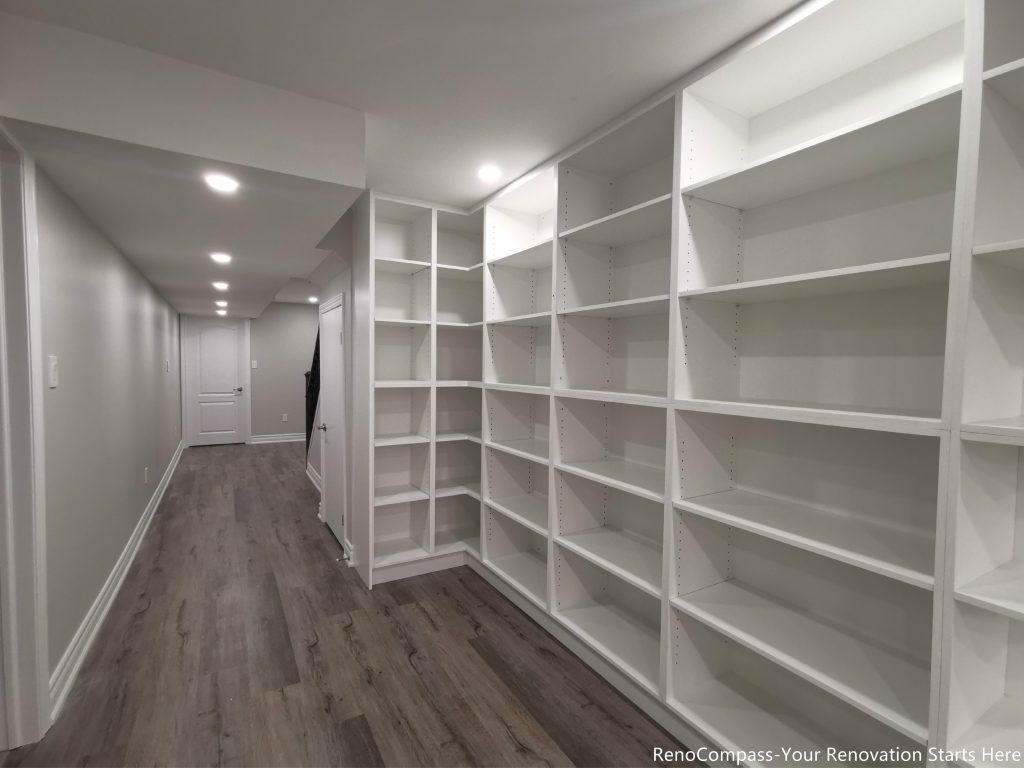 This Oakville basement renovation features custom built-in storage shelving designed to maximize organization and functionality in a modern finished basement. The upgraded space includes new flooring, smooth ceilings, recessed pot lights, and a clean hallway layout that enhances brightness and usability. Completed by a trusted Toronto renovation company, this basement renovation focuses on practical storage solutions, durable materials, and contemporary design, creating a versatile lower-level living space that adds long-term value to the home.