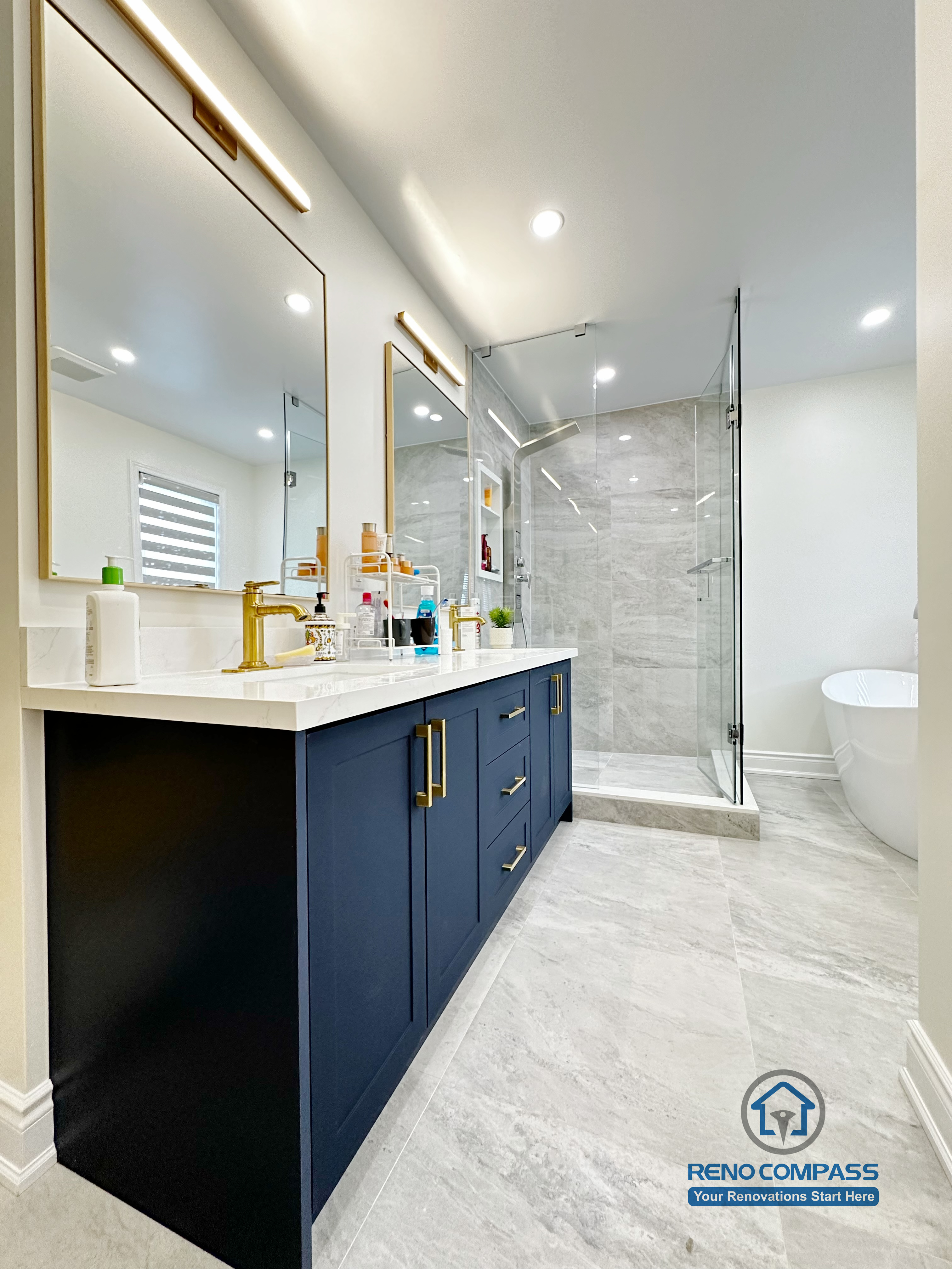 Master bathroom renovation in Markham featuring a frameless glass shower, large-format tile finishes, a custom vanity with matte black cabinetry, and brass fixtures. The design combines clean lines, efficient layout, and a refined modern aesthetic for everyday comfort.